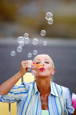 Happy woman blowing bubbles