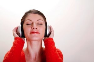 A woman listens to relaxing sounds on headphones